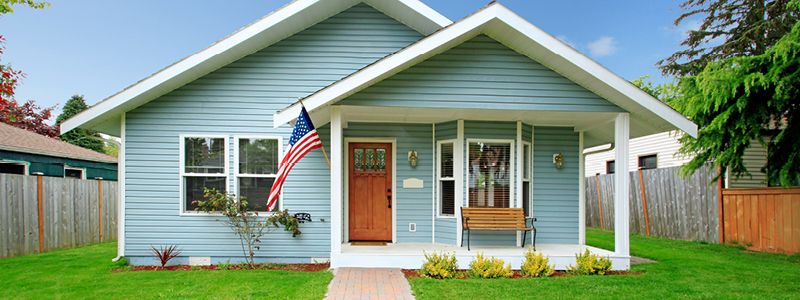 light blue cottage style home with white porch