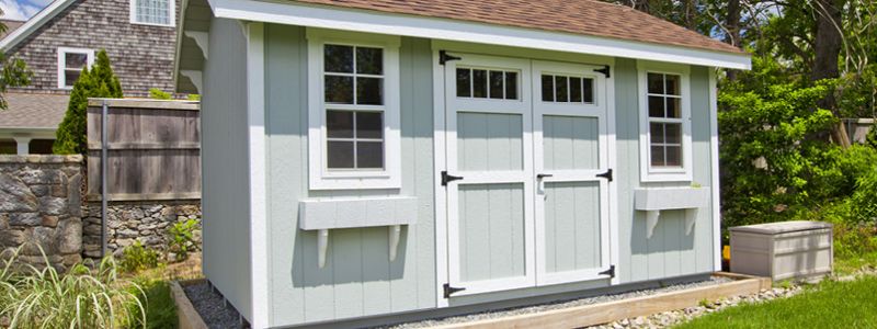 Light blue shed with barn doors and windows